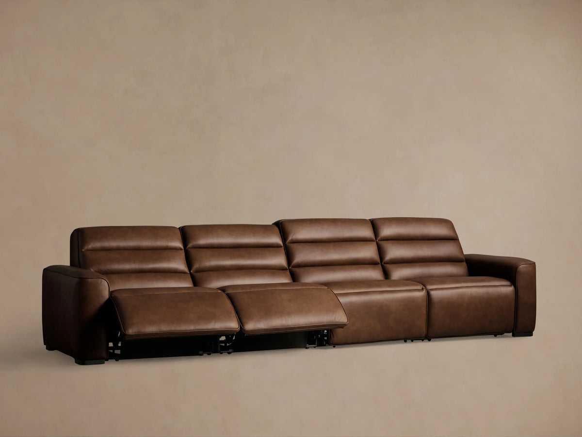 Close-up of rich brown leather Borough Motion Sectional with visible stitching and embedded metallic motion control buttons.