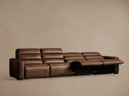 Borough Leather Four-Piece Motion Sectional in rich brown leather. Two leftmost footrests extended, against a light brown wall.