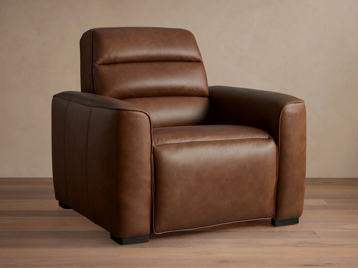 Borough Leather Motion Recliner, rich brown leather, padded back, wide arms, subtle piping, angled right.