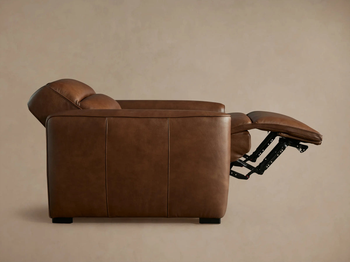 Rich brown leather Borough Motion Recliner, angled left, partially reclined with extended footrest and segmented back.