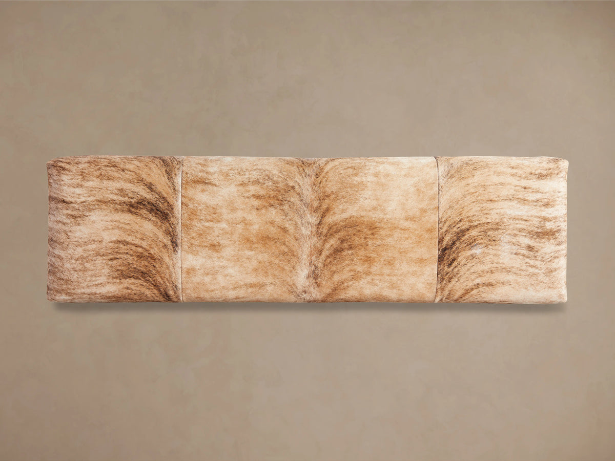 Tilton Hair on Hide Bench with a natural, undyed hide surface showing variations in shading. It rests on solid metal legs.