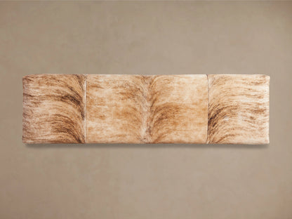 Tilton Hair on Hide Bench with a natural, undyed hide surface showing variations in shading. It rests on solid metal legs.