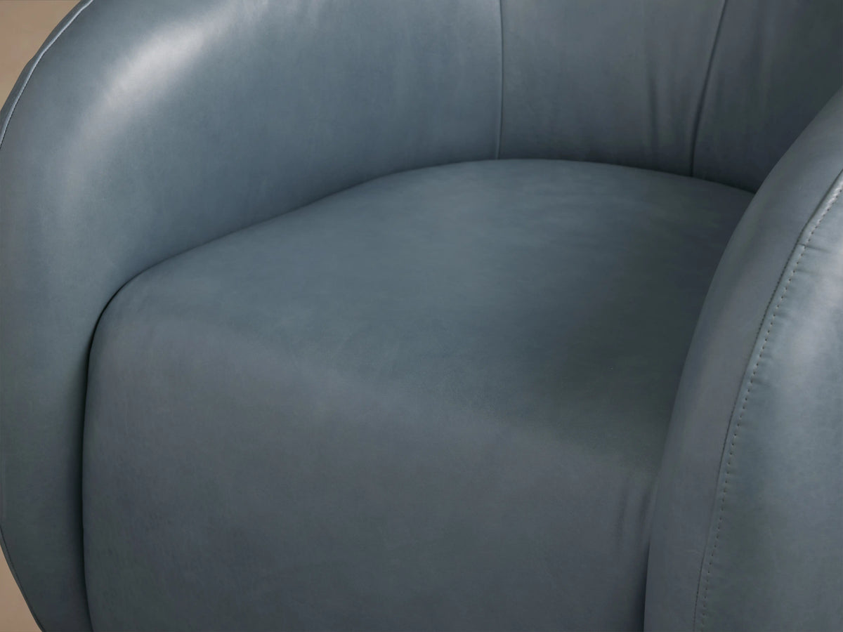 Fresno Leather Swivel Chair in smooth blue leather, with rounded back and arms, on a wooden floor with neutral background.
