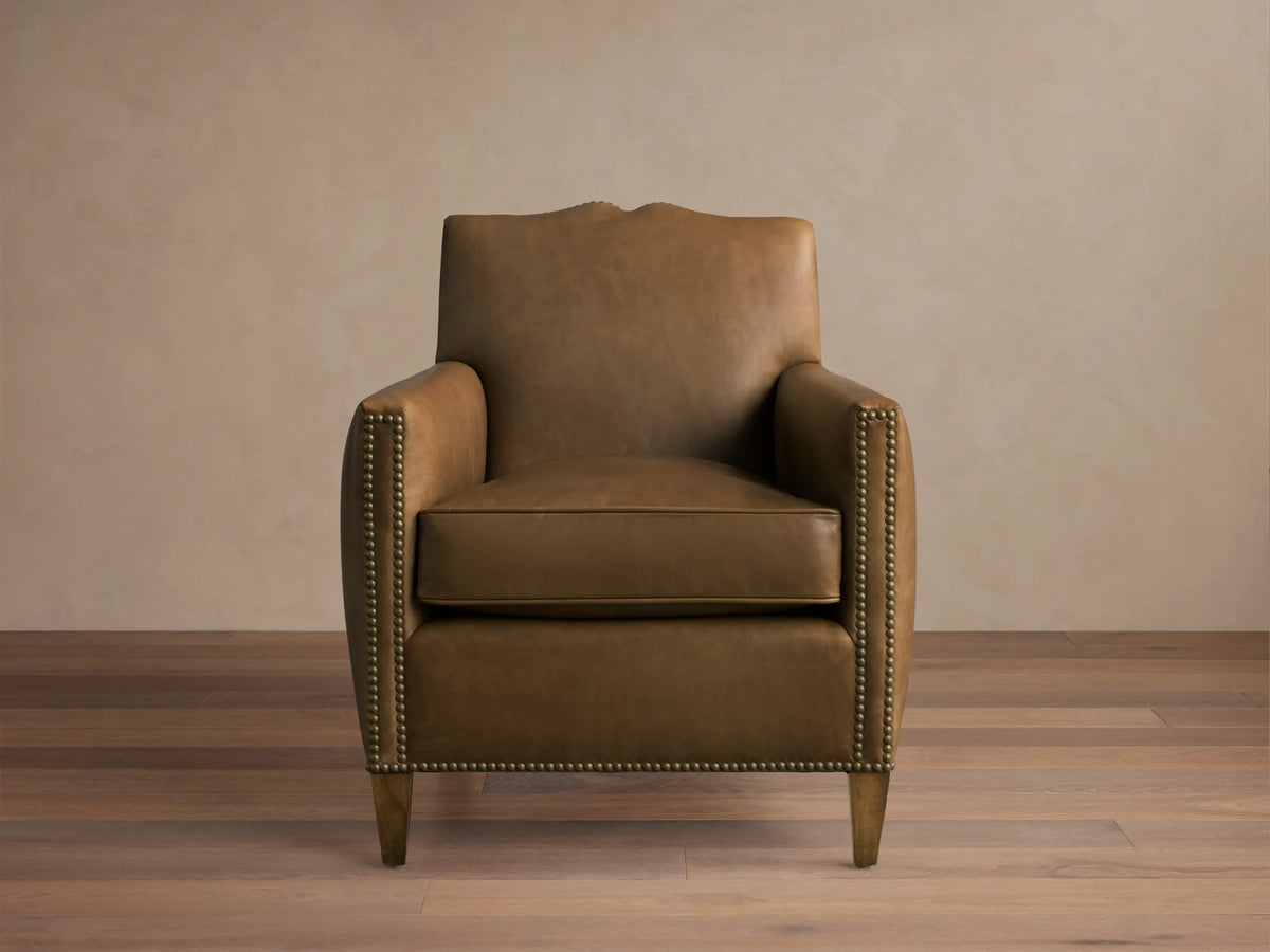 Front view of the tan brown Kinsman Leather Chair with natural-finished nailhead trim and sculpted mustache curve on the backrest.