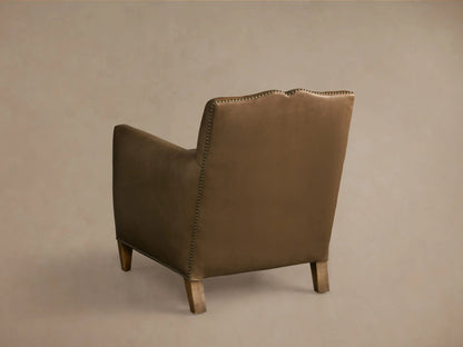 Rear view of a brown Kinsman Leather Chair with nailhead trim along the back and arms, sculpted backrest, and natural-finished legs.