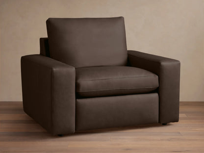 Wide arm leather motion recliner in dark brown leather, with plush seat and back cushions, on a wooden floor background.