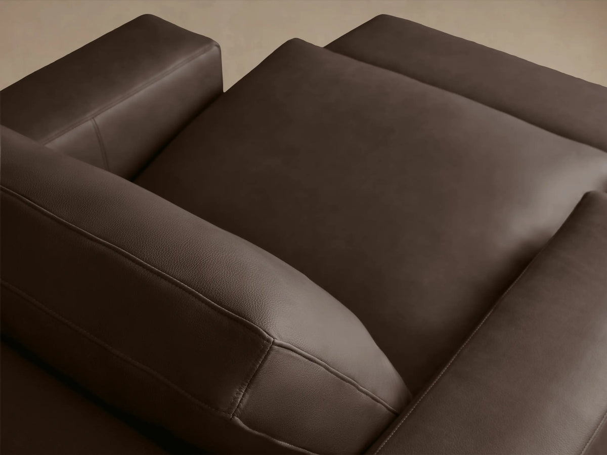 Kipton Wide Arm Leather Motion Recliner in brown leather, showing a close-up of the wide arm with a silver two-button control panel embedded.