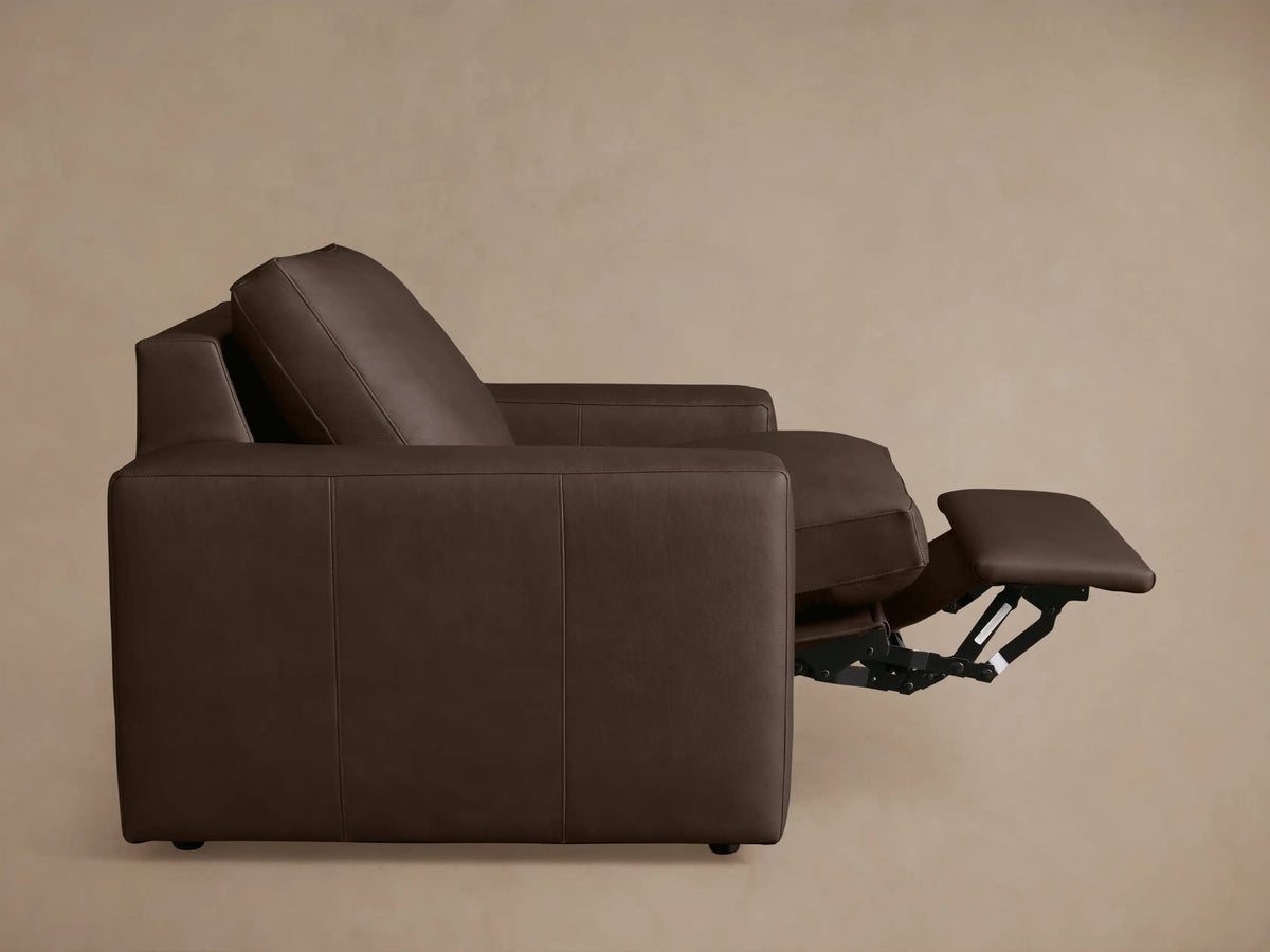 Back view of Kipton Wide Arm Leather Motion Recliner in dark brown leather, featuring wide arms, a tall backrest, and minimalist design.