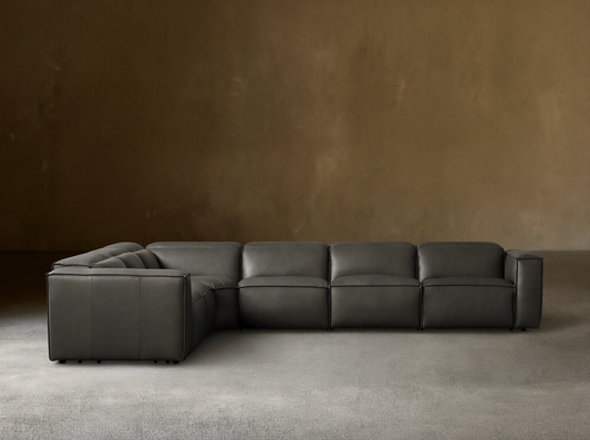 Dark gray leather Coburn Six Piece Motion Sectional, L-shaped, on a wood floor against a neutral wall.