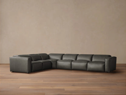 Dark gray leather Coburn Six Piece Motion Sectional, L-shaped, on a wood floor against a neutral wall.
