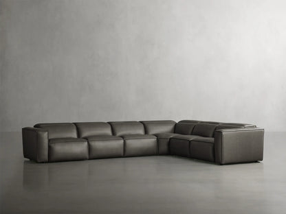 Coburn six-piece L-shaped sectional in dark grey leather, featuring plush seats and sleek design against a minimalist grey backdrop.