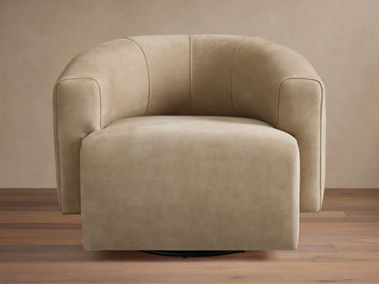 Hamlin Nubuck Leather Swivel Chair in beige, featuring a curved backrest and armrests, set on a wooden floor with a neutral backdrop.
