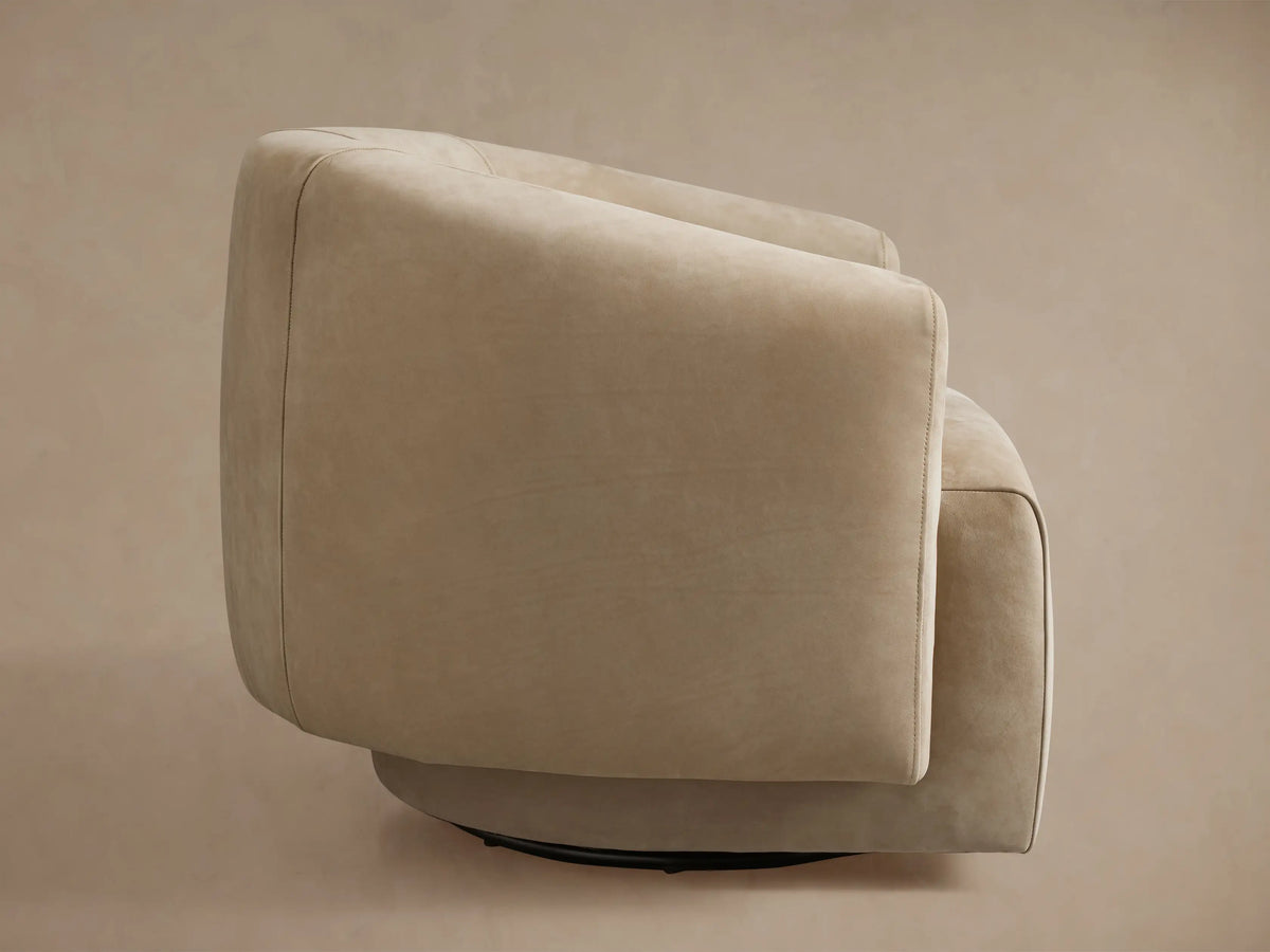 Hamlin Nubuck Leather Swivel Chair in beige, featuring a smooth, rounded backrest and plush armrest, close-up view.