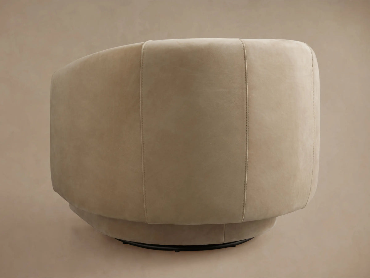 Hamlin Nubuck Leather Swivel Chair in beige, side view. Features a plush, curved backrest and seat with a 360-degree swivel base.