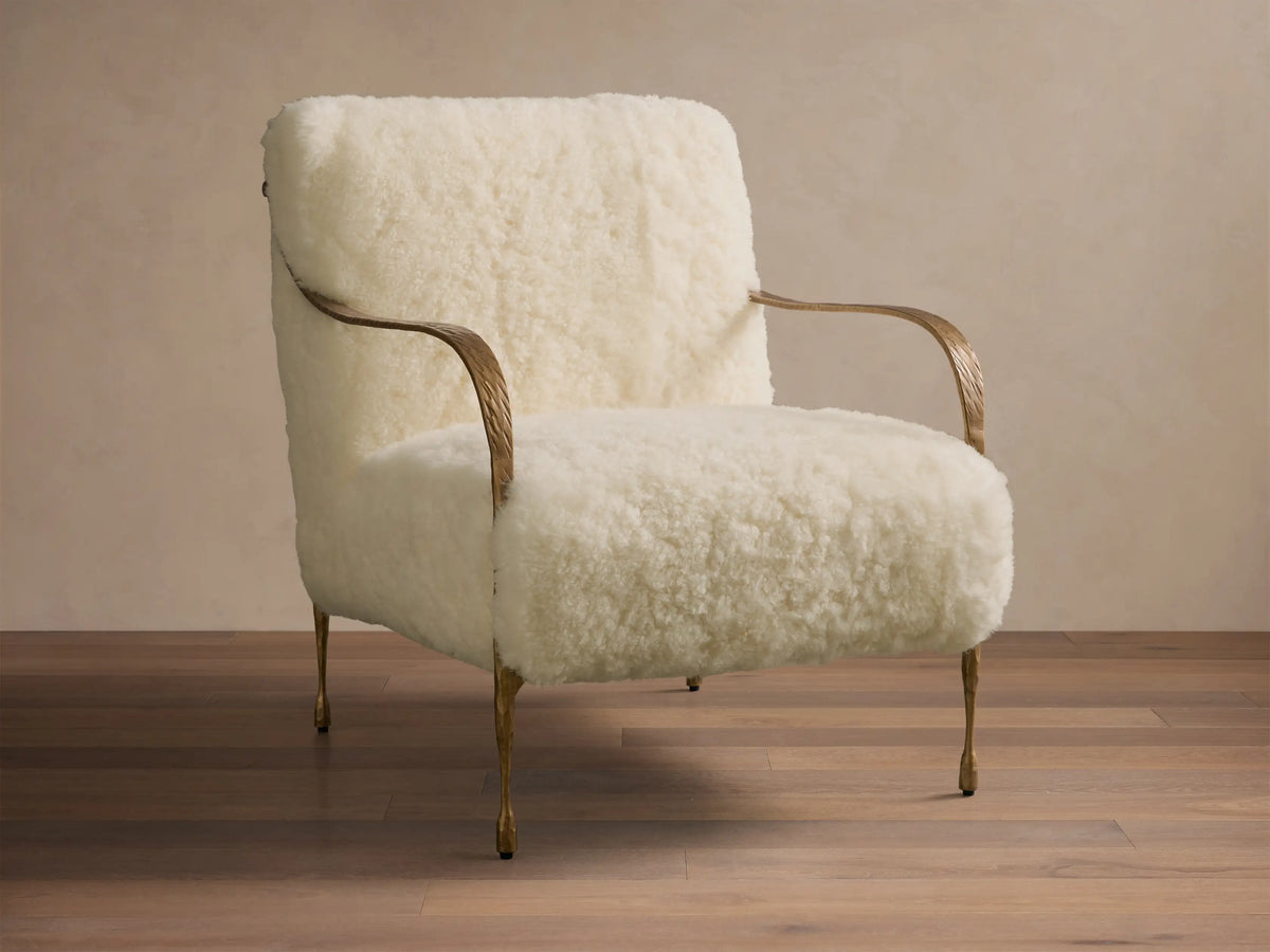 Front view of the Cream Gwen Shearling Chair with soft shearling upholstery and textured brass-finished legs.