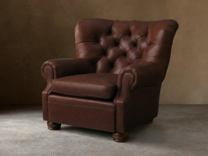Front view of a brown tufted leather armchair with rolled arms and a single seat cushion.