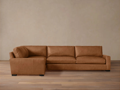 Remington Leather Two-Piece Sectional. L-shaped, warm brown leather sofa with plump cushions, dark block feet, on wood floor.