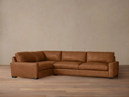 Remington Leather Two-Piece Sectional. L-shaped, warm brown leather sofa with plump cushions, dark block feet, on wood floor.