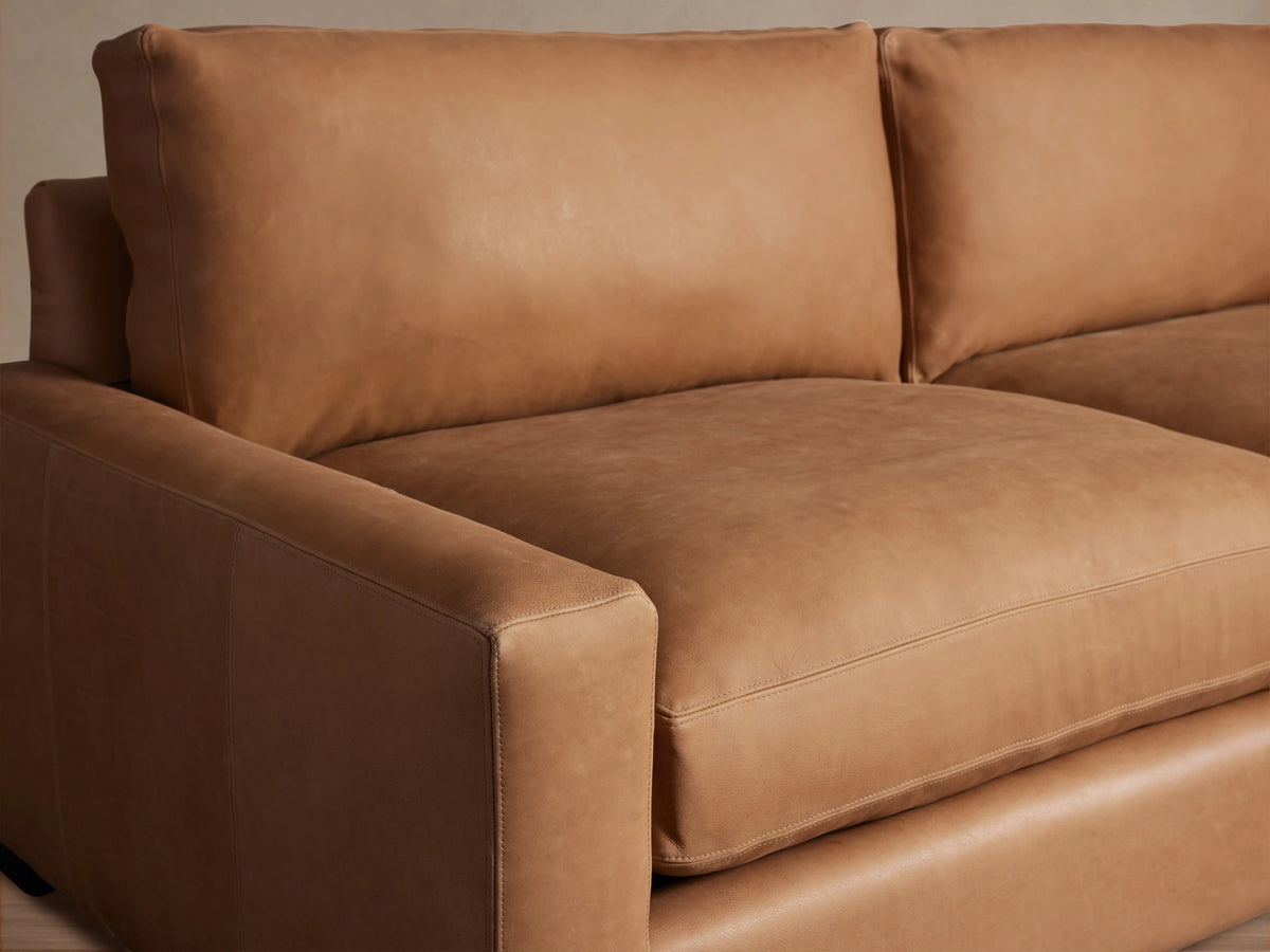 Remington Leather Sofa in tan leather, featuring plush seat and back cushions, square arms, and dark wooden block feet.