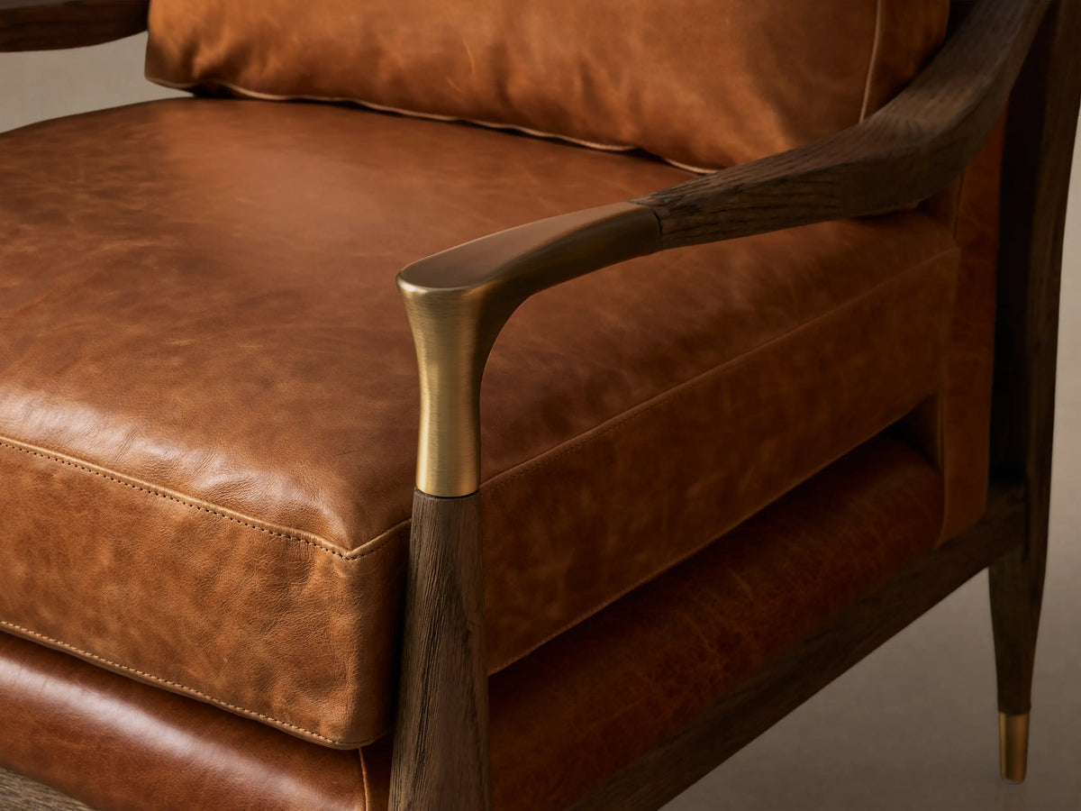 Front view of the brown leather Fisher Leather Chair, featuring a dark oak wood frame with curved armrests and brass accents.