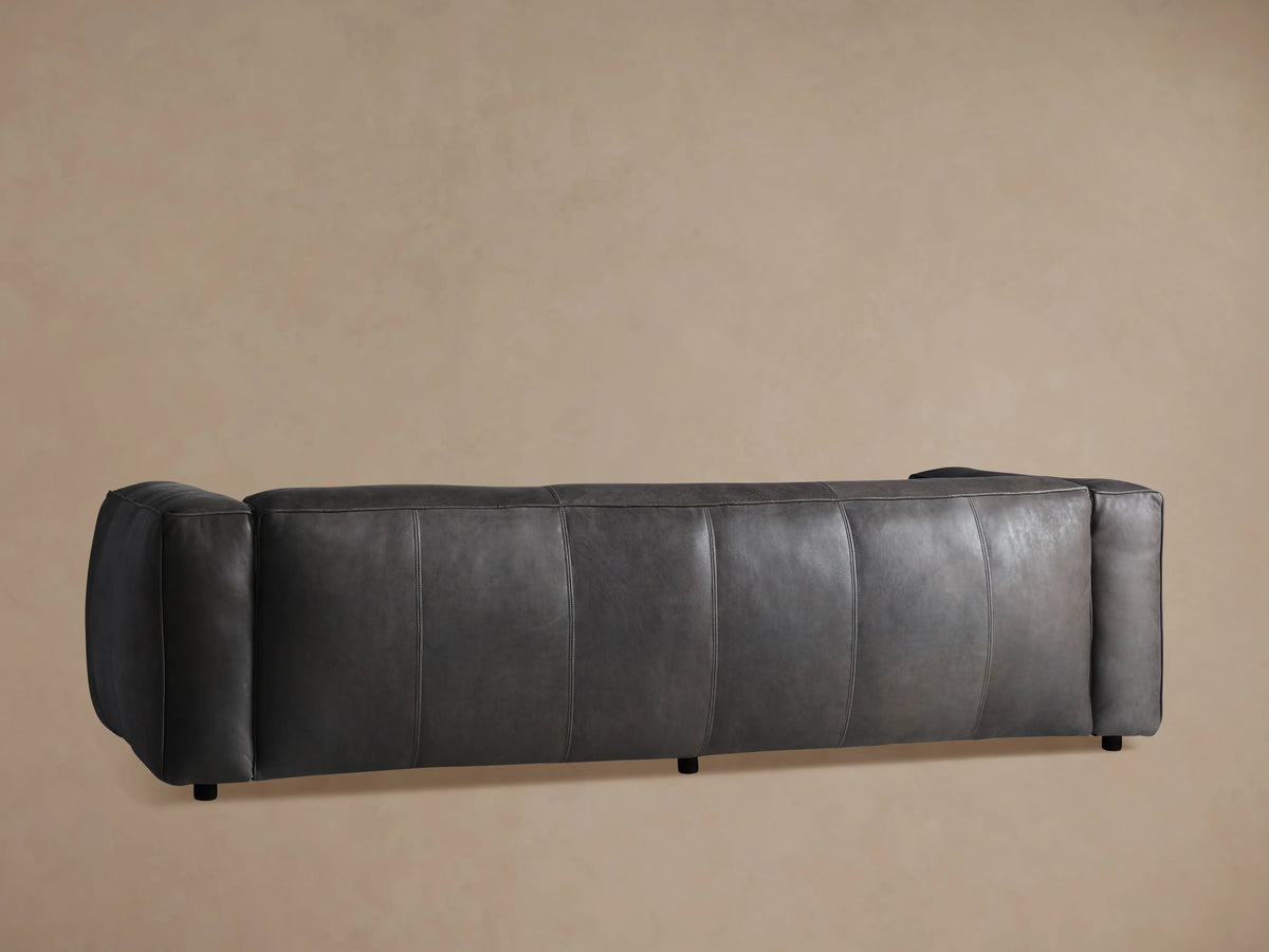 Detailed close-up of the Madrone Leather Sofa's dark charcoal grey distressed leather upholstery with visible stitching and piping.