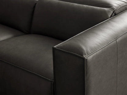 Dark gray Coburn Leather Two-Piece Motion Sofa with square arms and visible piping, on a wooden floor.