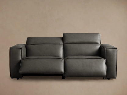 Dark charcoal grey Coburn Leather Motion Sofa, close-up of a square armrest, seat, and back cushion with visible stitching.