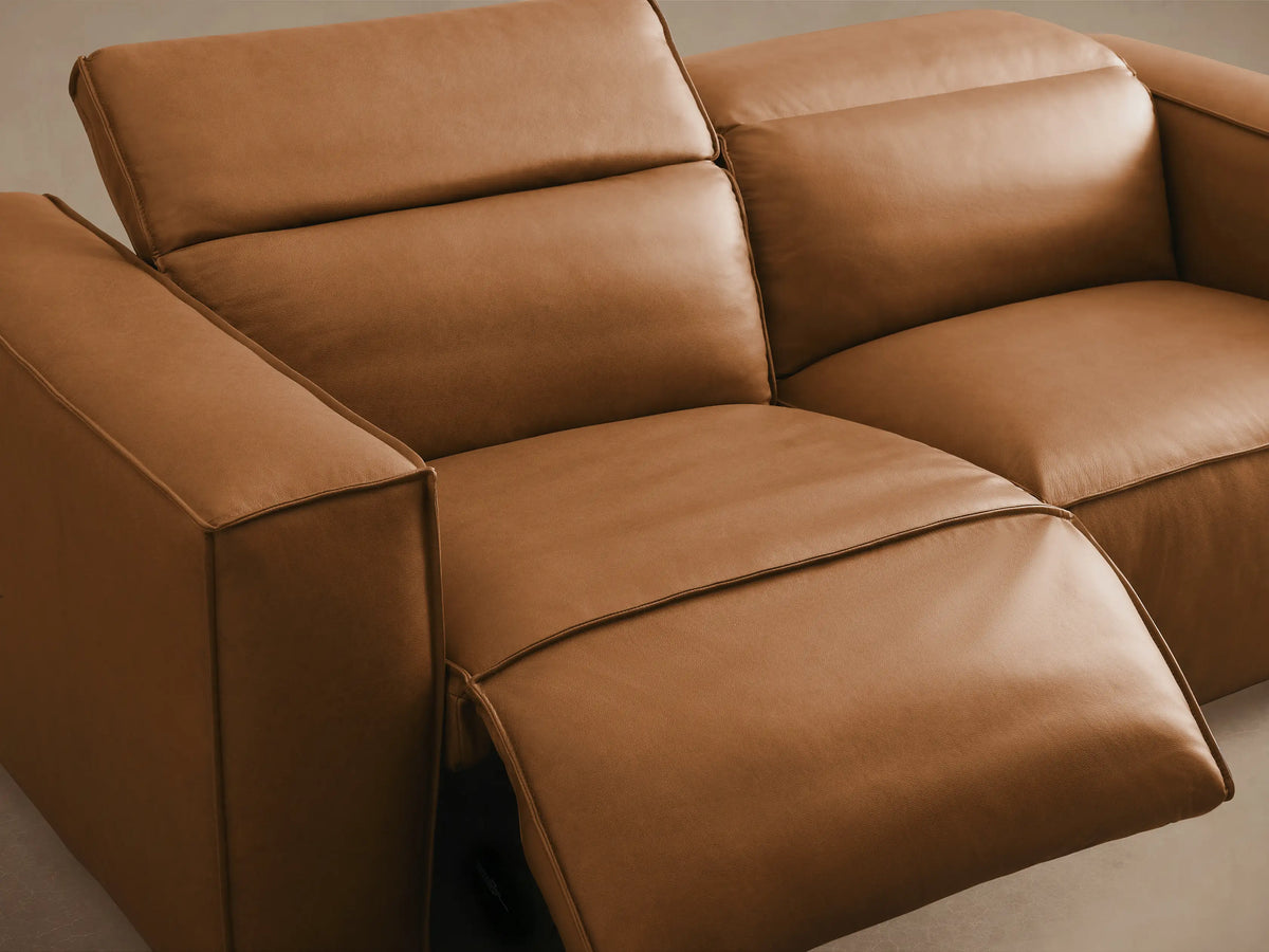 Coburn Leather Two-Piece Motion Sofa in brown leather; features left and right arm recliners with plush cushions on wooden floor.