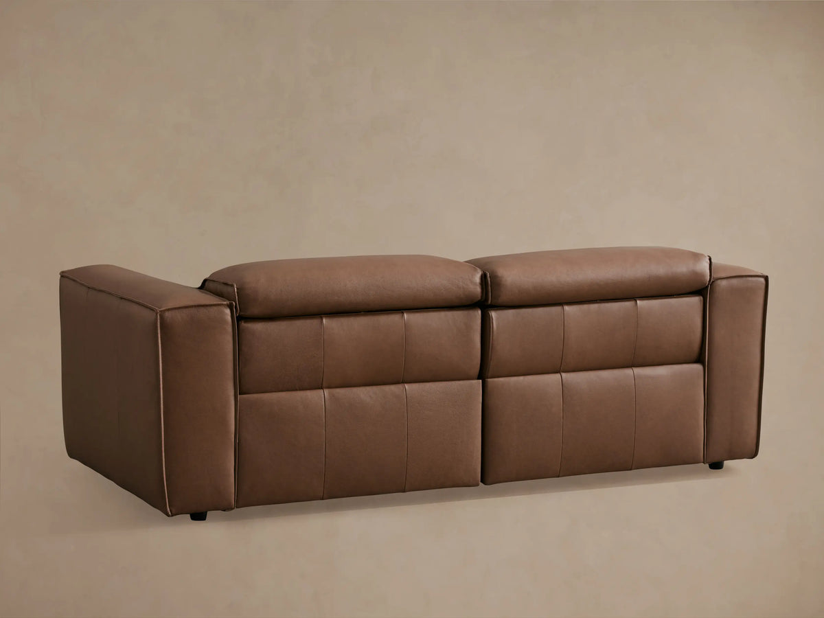 Coburn Leather Two-Piece Motion Sofa in brown leather, featuring reclined seat with extended footrest and sleek arm design.