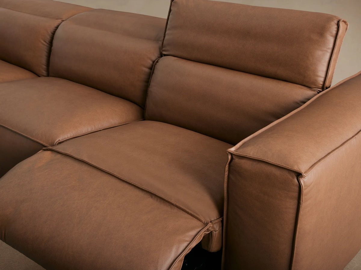 Coburn Leather Three-Piece Motion Sofa in brown, three sections, cushioned seats, straight backrests, set on wood flooring.