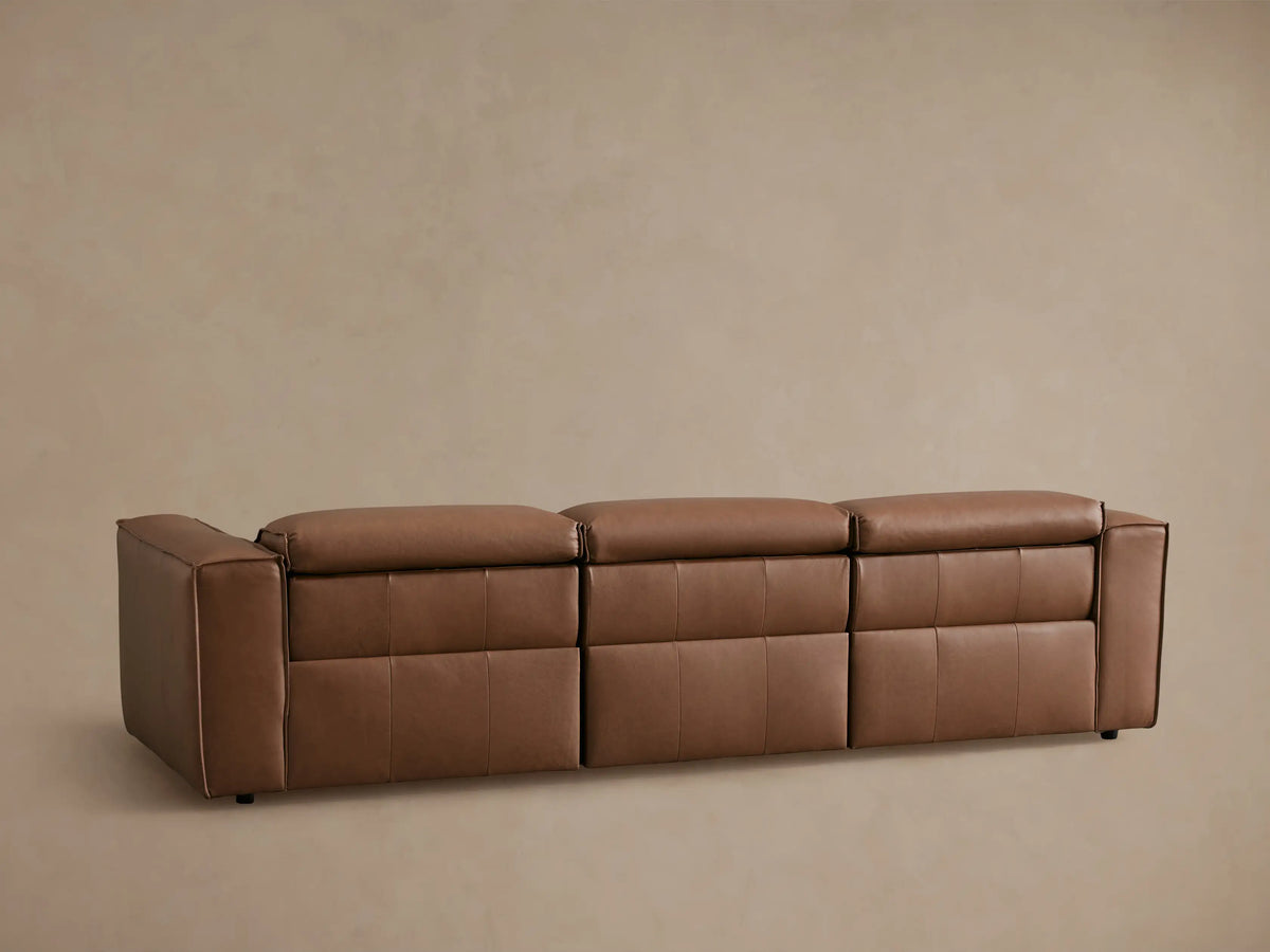 Coburn Leather Three-Piece Motion Sofa with brown buttery leather, visible stitching, and reclined seat. Right armrest and sleek design.
