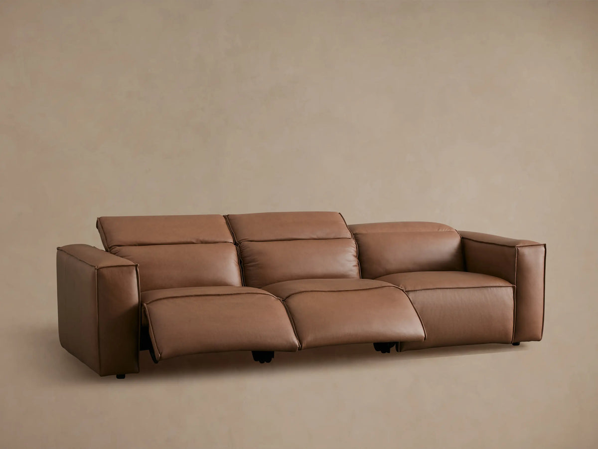 Coburn Leather Three-Piece Motion Sofa in brown leather with one recliner extended, featuring a modern design and plush seating.