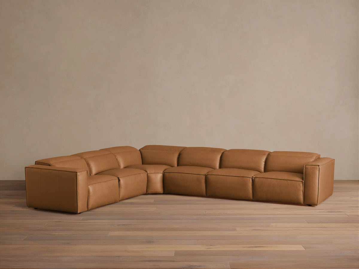 Coburn Leather Six Piece Motion Sectional in caramel brown leather on wooden floor, featuring left and right arm recliners with plush cushions, arranged in an L-shape.
