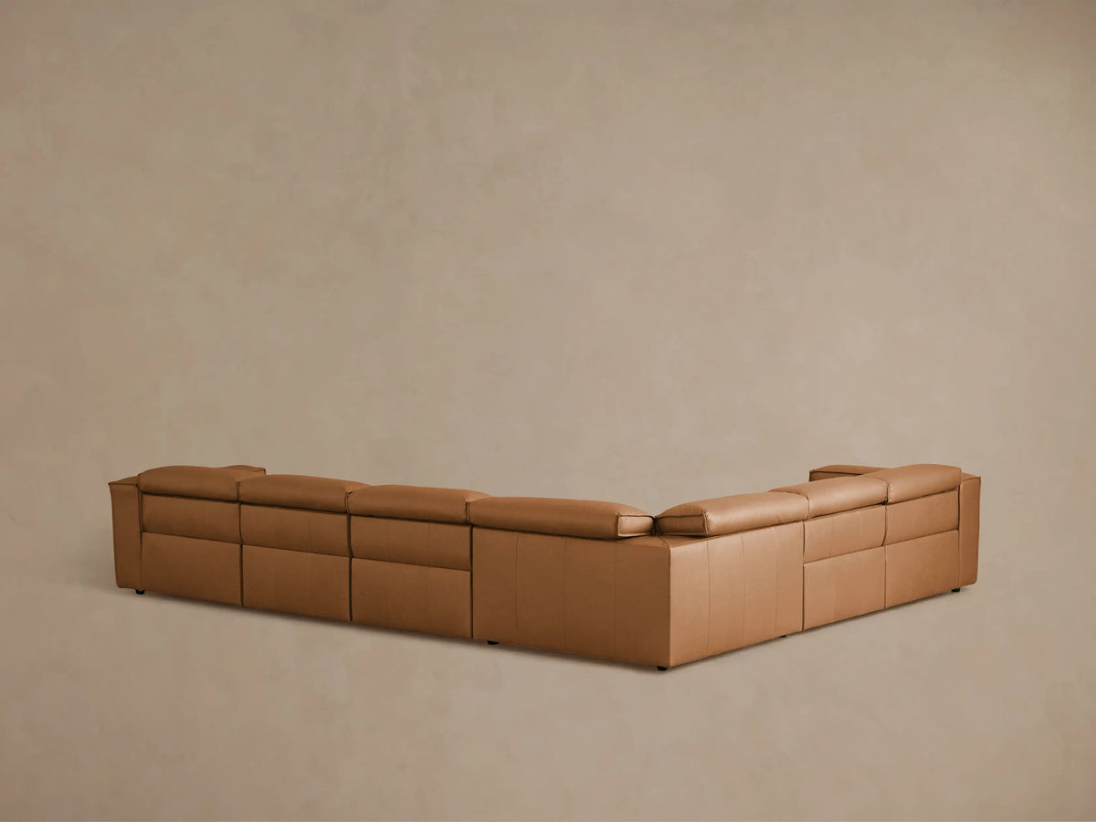 Coburn Leather Six Piece Motion Sectional in caramel brown leather, featuring sleek design with recliner extended, showing plush seating and backrest.
