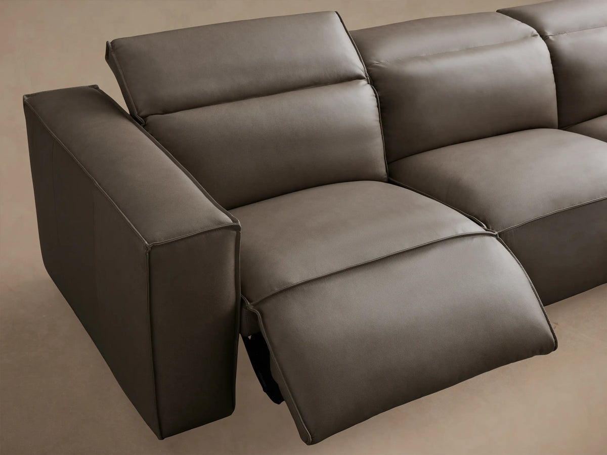 Coburn Leather Six Piece Motion Sectional in semi-aniline dyed leather, featuring left arm recliner, three armless sections, corner, and right arm recliner. Wood floor background.