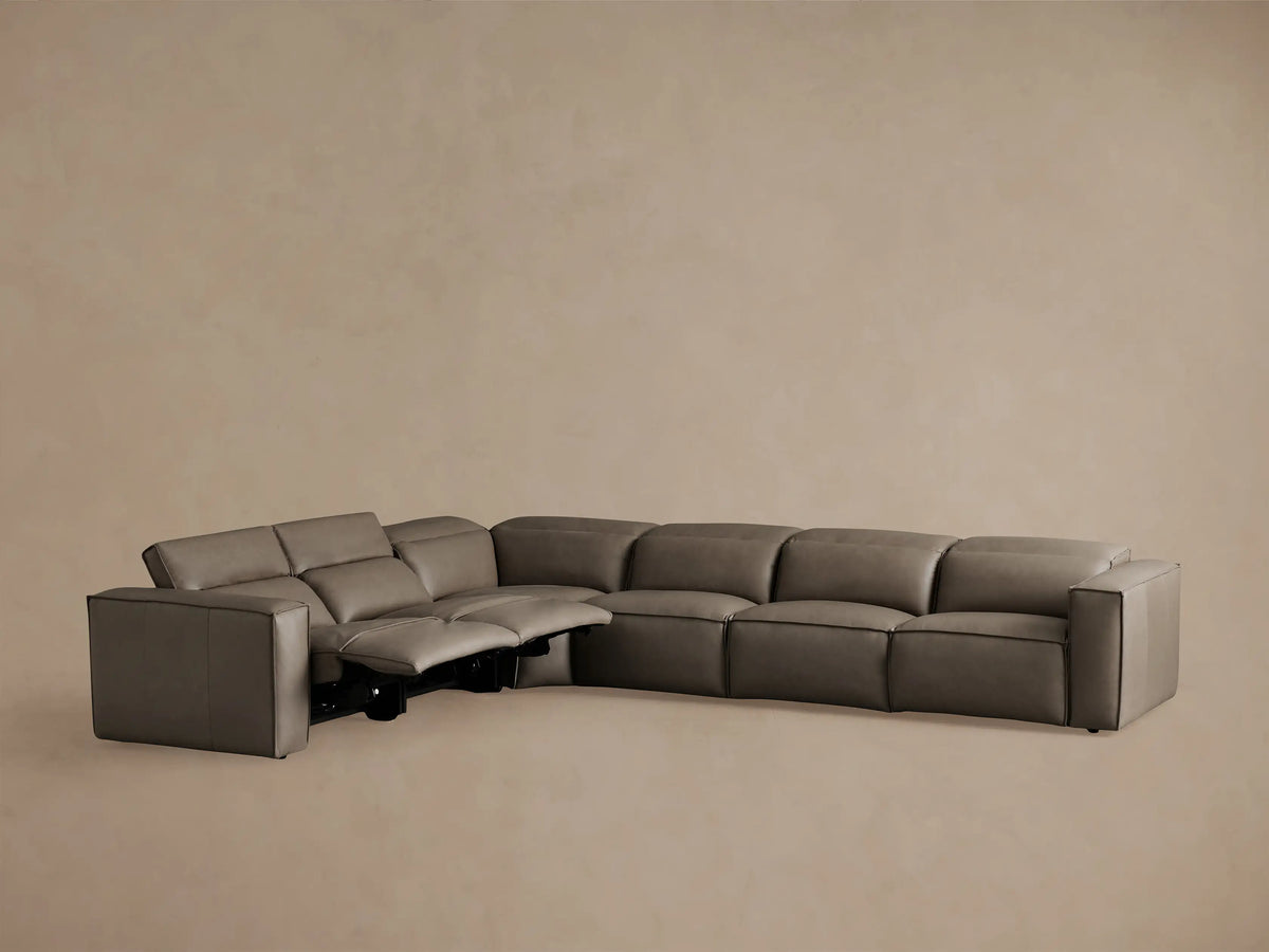 Coburn Leather Six Piece Motion Sectional in brown leather, shown from the back at a slight angle. The sectional is in an L-shape with visible smooth seams.