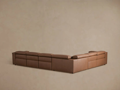 Brown leather sectional with reclined seat on the right, featuring smooth, cushioned backrests and detailed stitching.