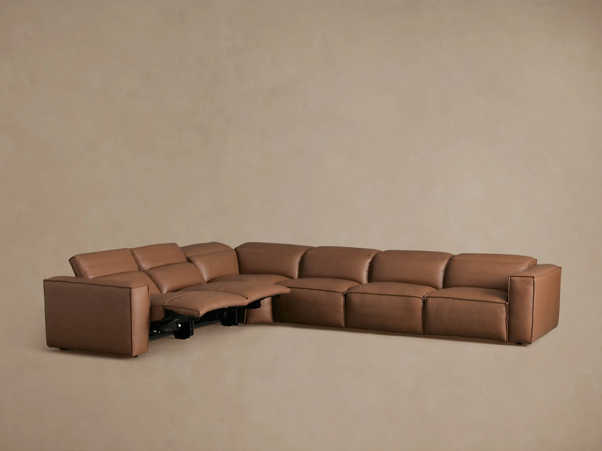 Coburn Leather Six Piece Motion Sectional in a warm brown color, L-shaped arrangement, viewed from the back and side, highlighting sleek, buttery leather texture.