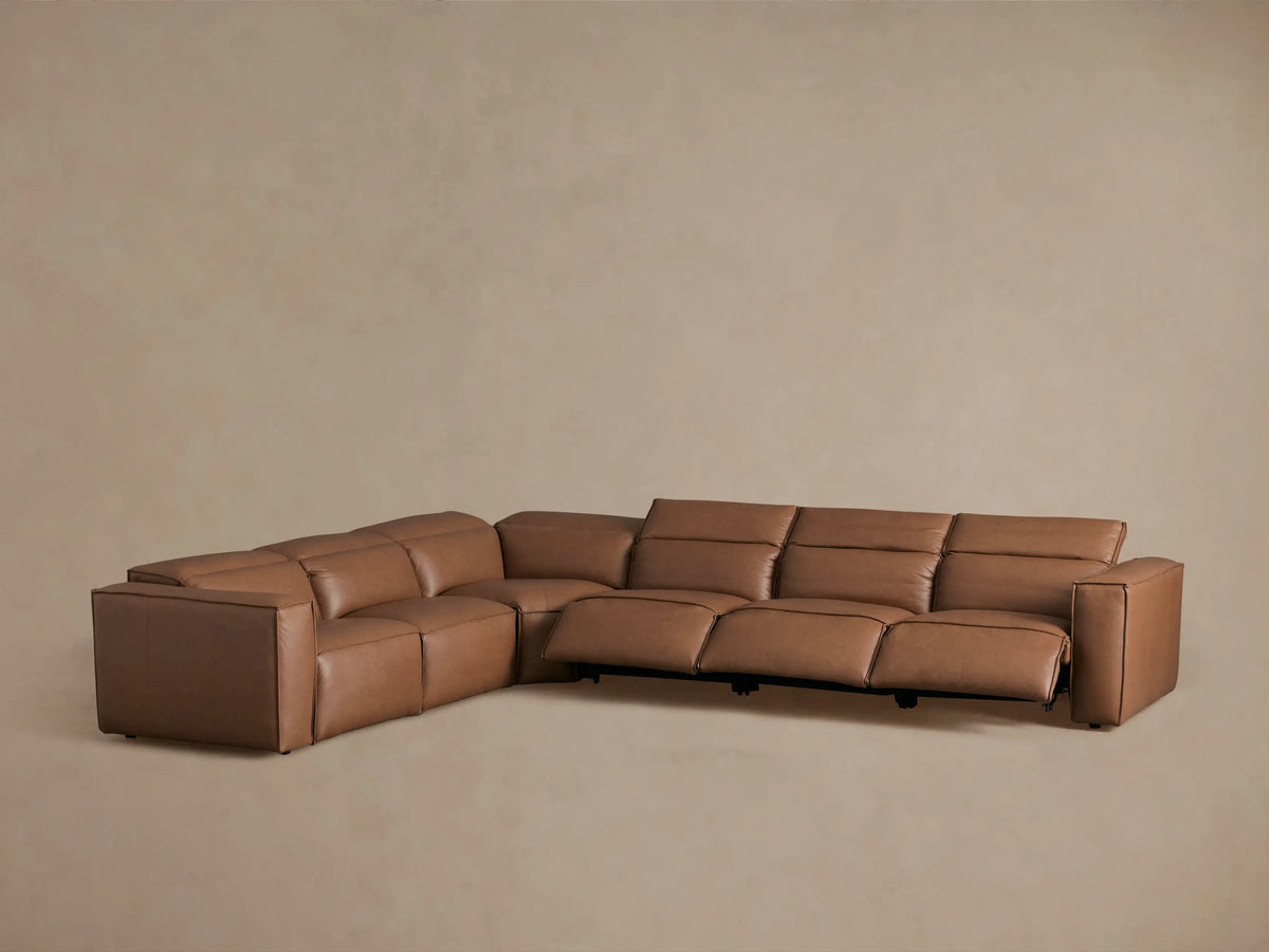 Coburn Leather Six Piece Motion Sectional in brown leather, featuring reclining seats and visible footrests extended in the corner.