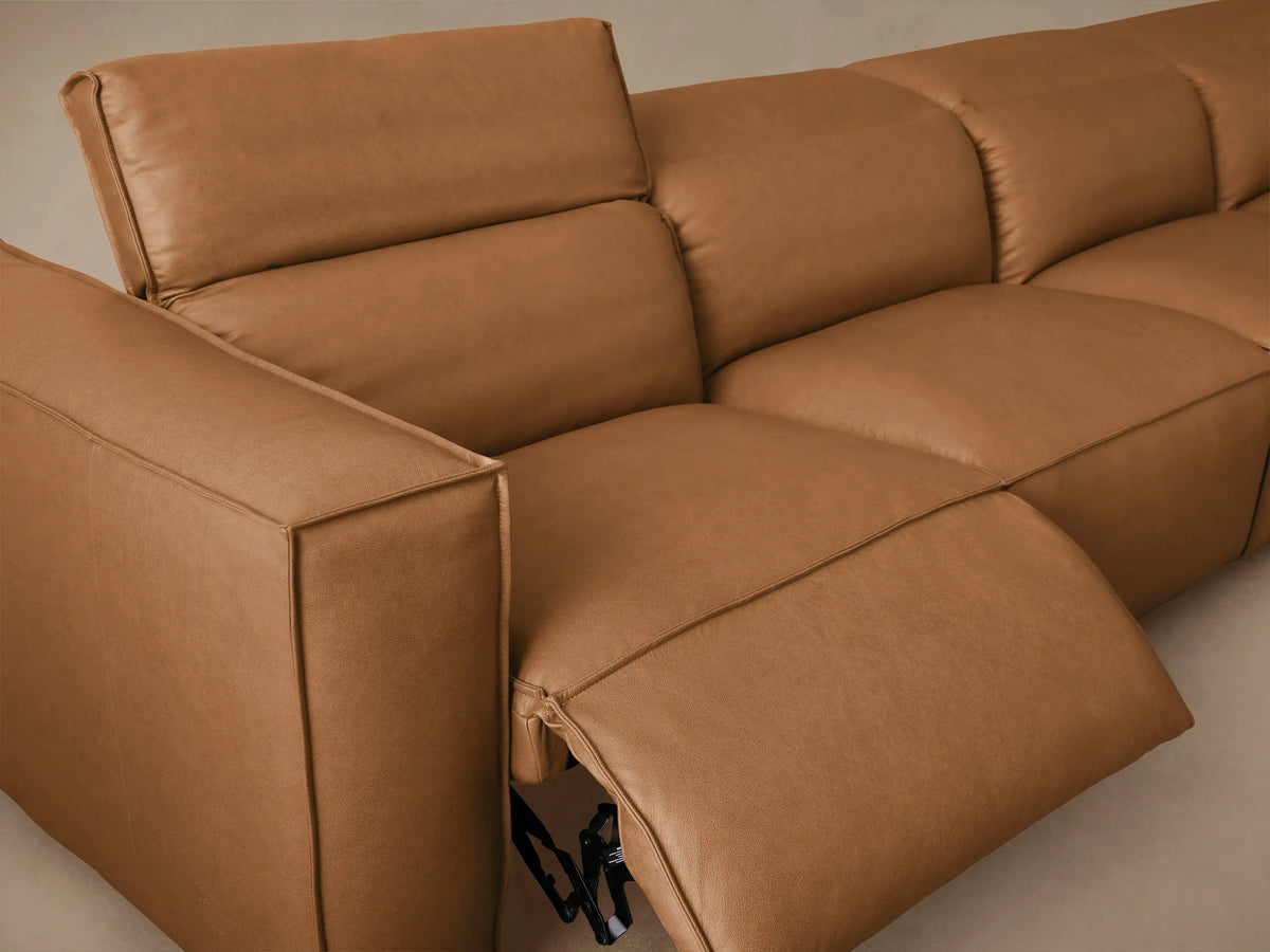 Coburn Leather Six Piece Motion Sectional in warm brown, featuring plush backrests and sleek design, arranged in an L-shape on wooden floor.