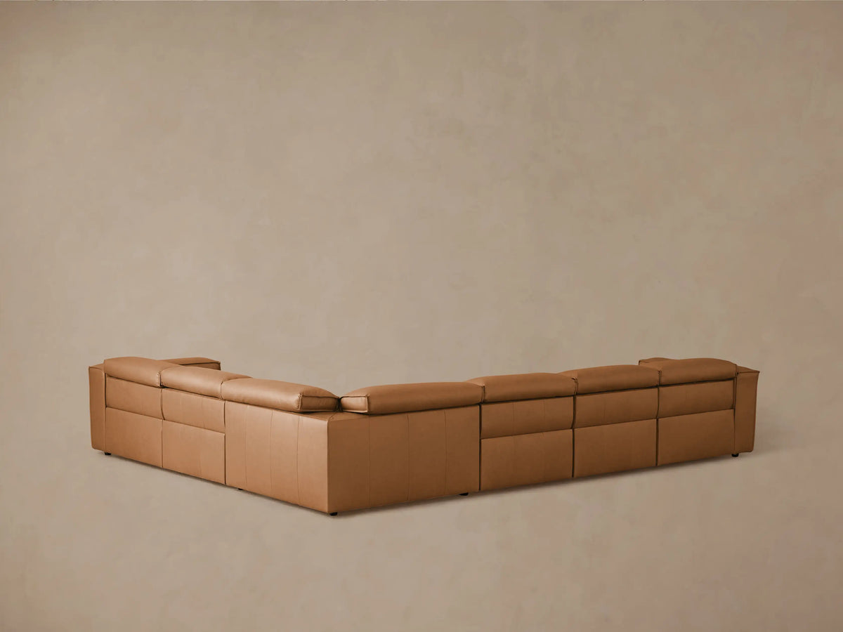 Coburn Leather Six Piece Motion Sectional shown in tan leather with a left arm recliner extended, displaying plush cushions and sleek modern design.