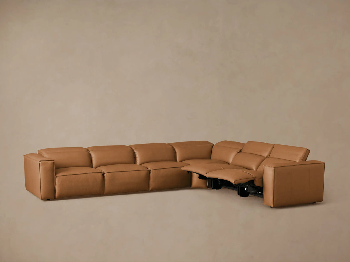Coburn Leather Six Piece Motion Sectional in tan leather, L-shaped, viewed from rear. Features include visual grain, smooth surface.