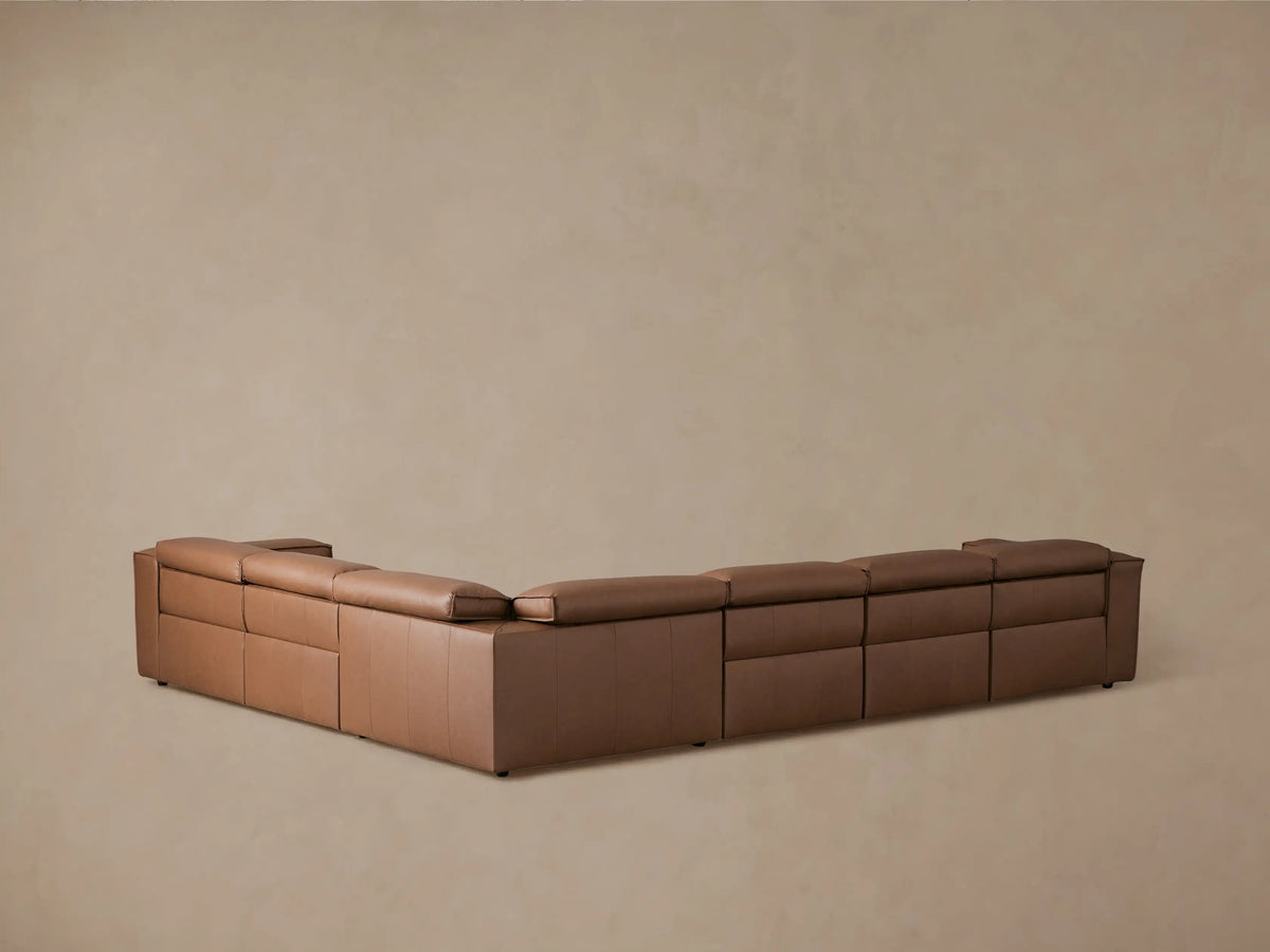 Coburn Leather Six Piece Motion Sectional in brown leather, showcasing a reclined seat with footrest extended. Smooth, plush cushioning.