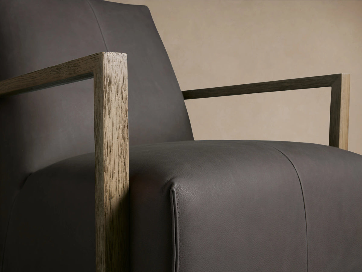 Walsh Leather Glider in dark brown leather with a high back, square wooden armrests, and a round swivel base on wood floor.