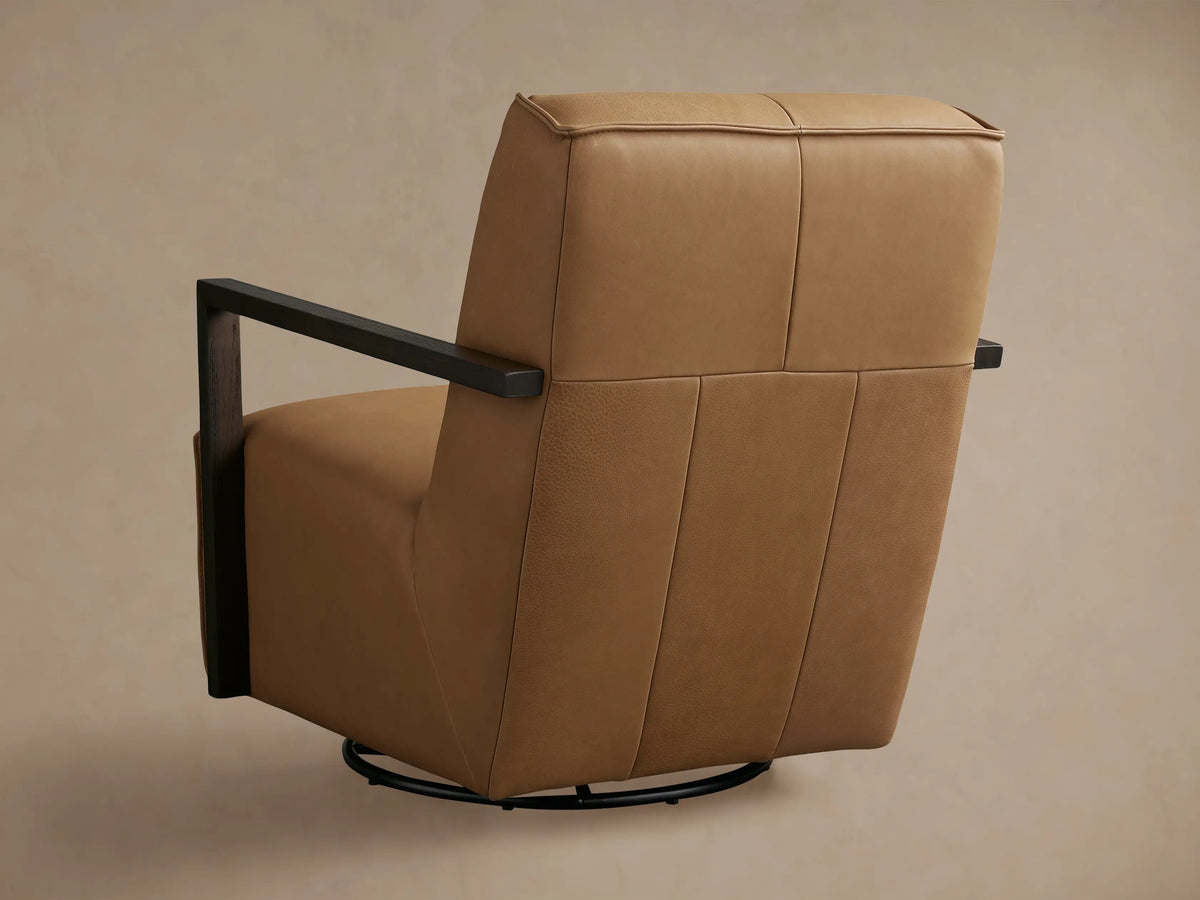 Close-up, angled view of a tan leather Walsh Glider, showing the seat, back, and dark wood armrests with visible grain.