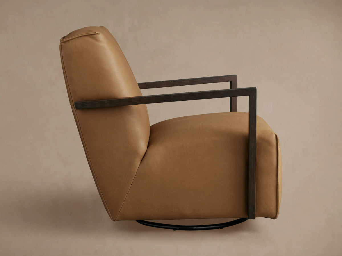 Tan leather Walsh Glider chair, seen from the back, featuring dark armrests and a circular black swivel base.