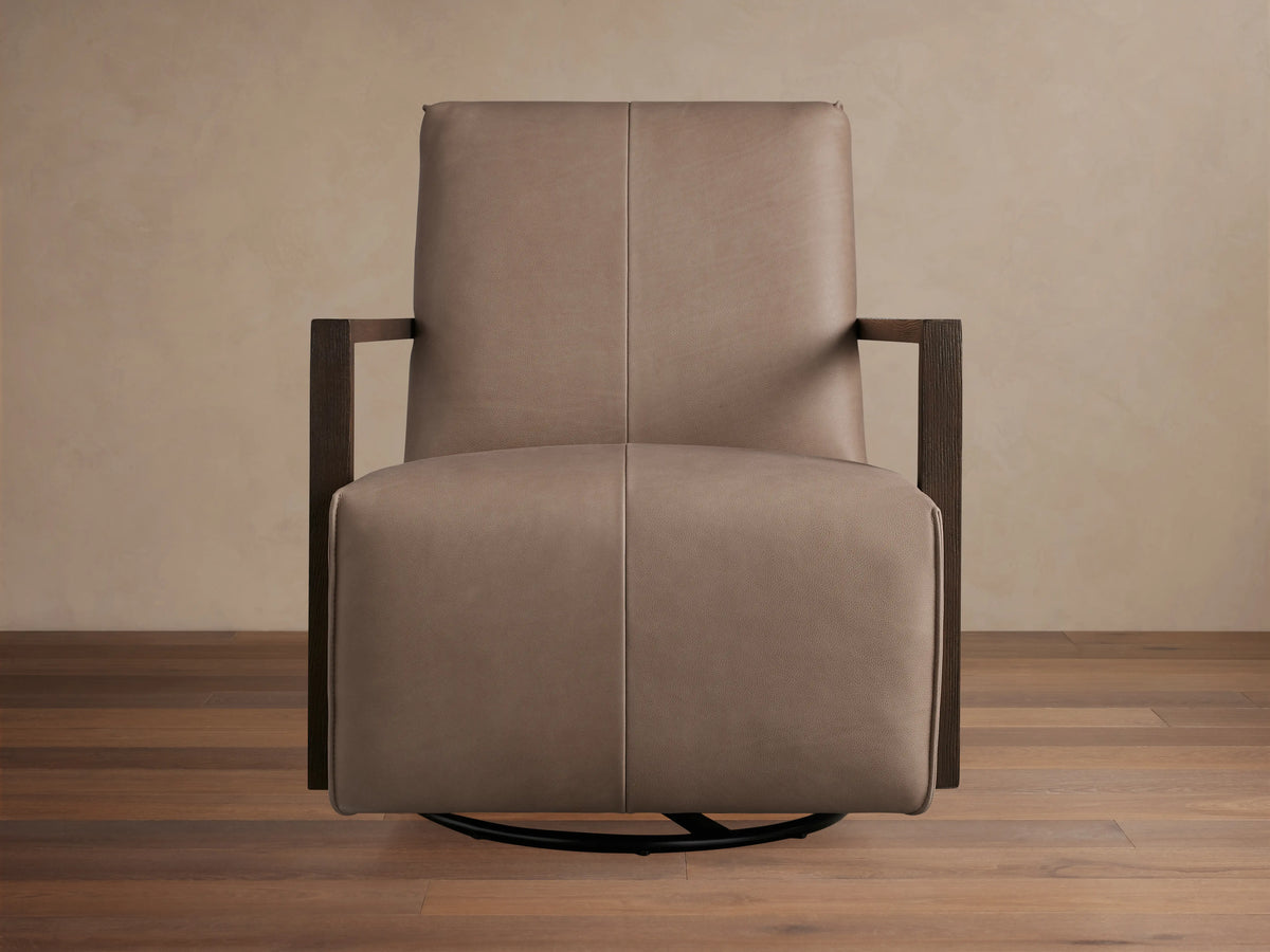 Close-up of Walsh Leather Glider with textured light brown leather upholstery and dark brown wooden armrests.