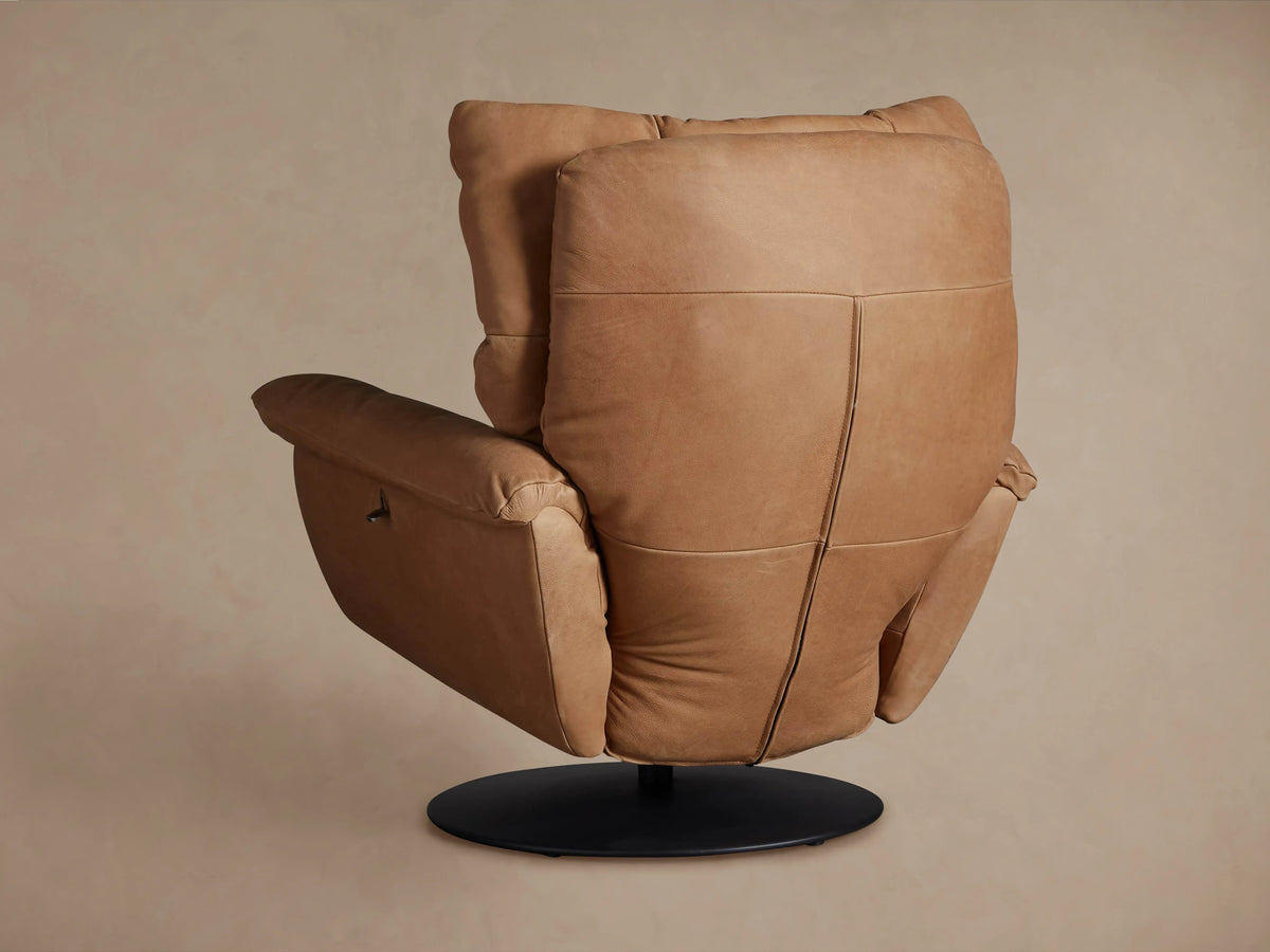 Close-up of the Deacon Leather Swivel Recliner, showing its tan padded leather armrest & side with a dark reclining lever.