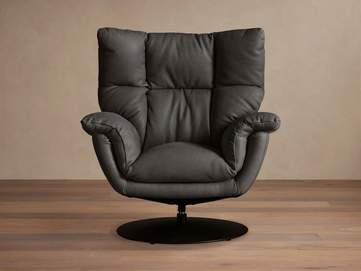Dark gray Deacon Leather Swivel Recliner with deeply cushioned back & arms, soft leather, on a round black swivel base.