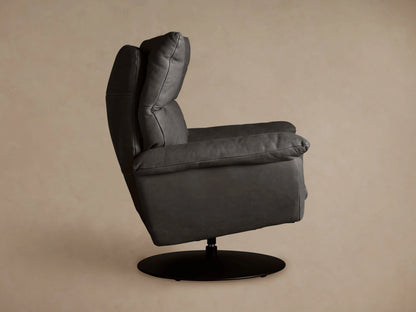 Deacon Leather Swivel Recliner, charcoal gray, seen from back at an angle. Padded backrest with seams, black circular swivel base.